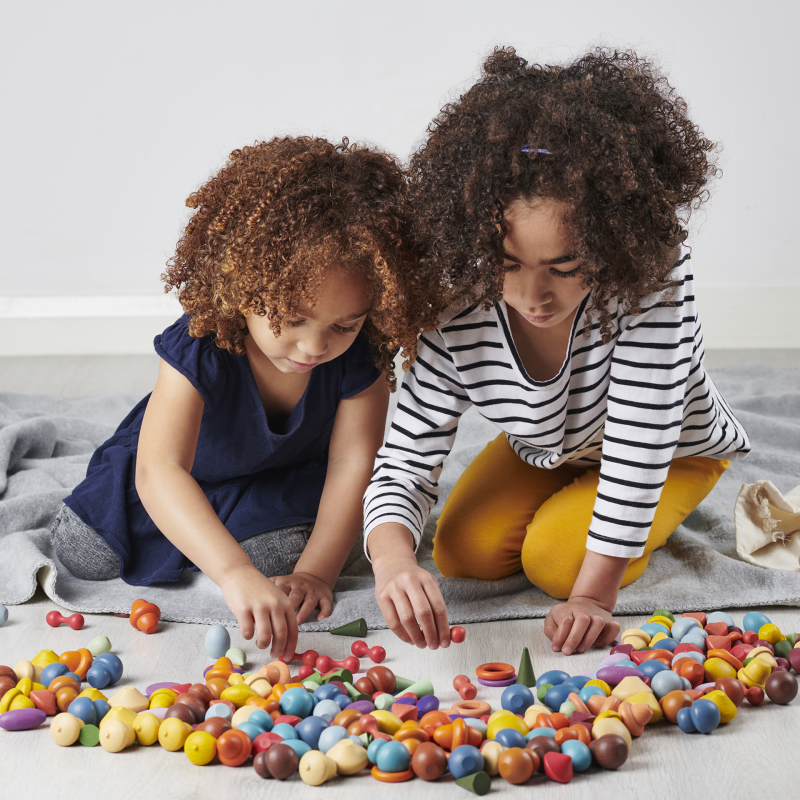 sibling playing with tickit wooden toys passed down from older children